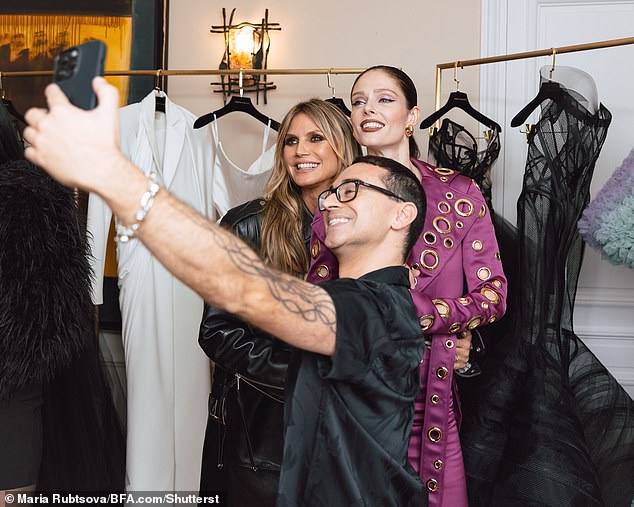 Heidi was photographed taking a selfie with Christian and Coco, who looked chic in a purple dress with cut-out circle sections