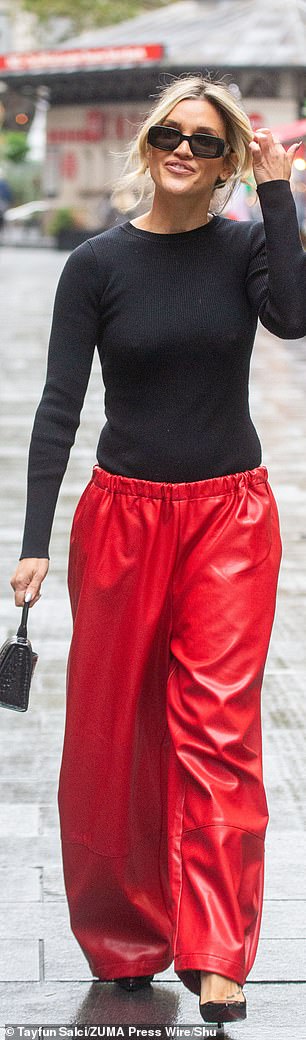 Elsewhere, Ashley, 43, rocked a statement street style as she wore a matching long-sleeved black T-shirt, teamed with striking red oversized trousers, which she layered with black stilettos