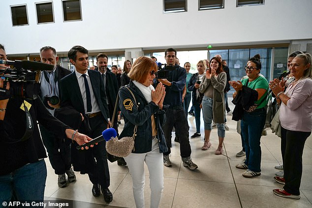 Gisele Pelicot (center) receives applause from the audience as she arrives at the Avignon courthouse during the trial