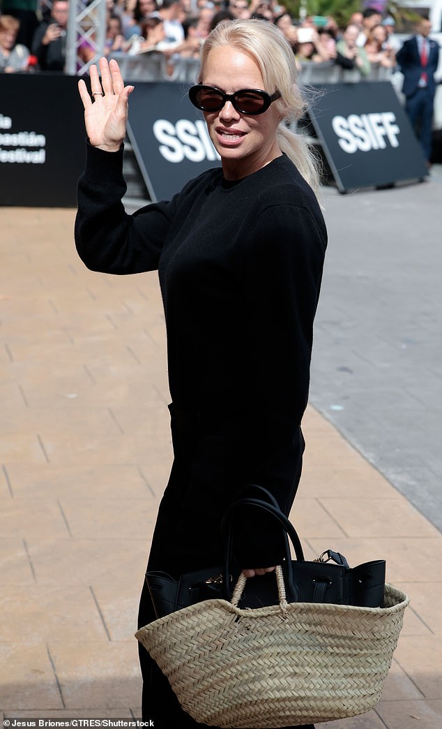 The model carried a woven straw and black leather handbag