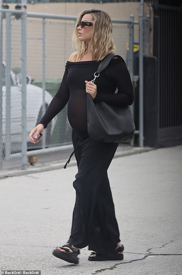 The Barbie star showed off her growing baby bump in a sheer black off-the-shoulder top and comfy oversized sweatpants