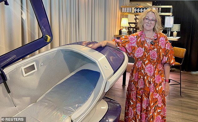 Last Resort member Fiona Stewart poses next to Sarco's suicide machine in July