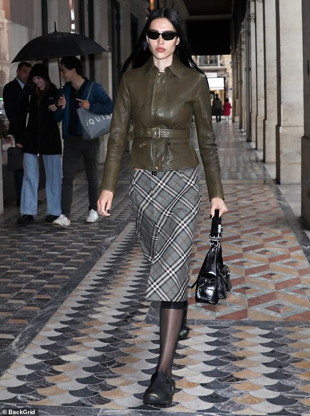 Amelia completed her look with sheer, knee-high black socks, black sneakers and a shiny black handbag