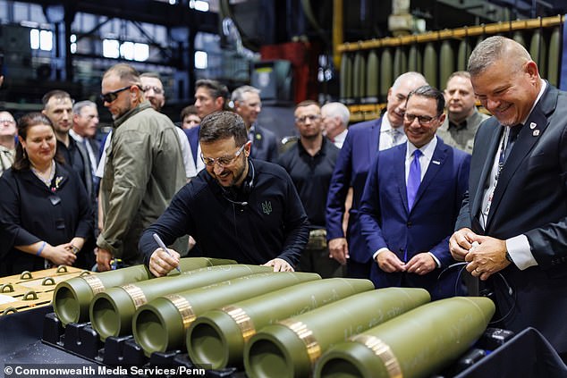 Zelensky smiles as he signs a 155mm artillery shell likely destined for battlefields in his country that have left hundreds of thousands of life-changing and life-ending casualties. Shapiro (R 3) and Casey (R 4) are seen in blue suits