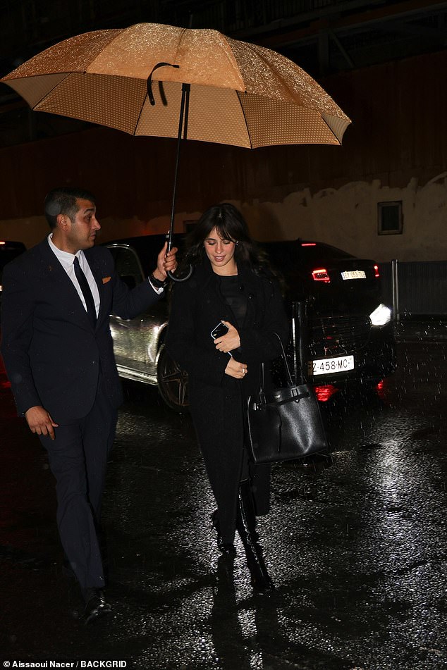 This time, Camila enlisted a different umbrella attendant as she walked into the restaurant dressed entirely in black