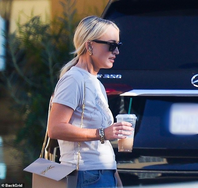 She showed off her best features in a plain white top paired with jeans as she walked down the scenic street in the upscale LA suburb