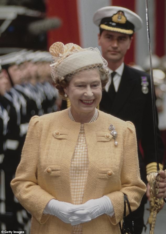 Commander Timothy Laurence walks behind the Queen during a commissioning ceremony for HMS Invincible in 1989