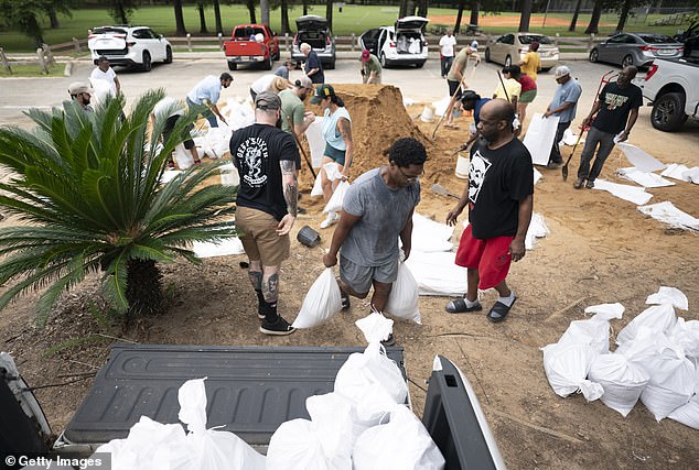 People gather sand in preparation for possible flooding in Helene, which could total 5 to 10 inches of rain