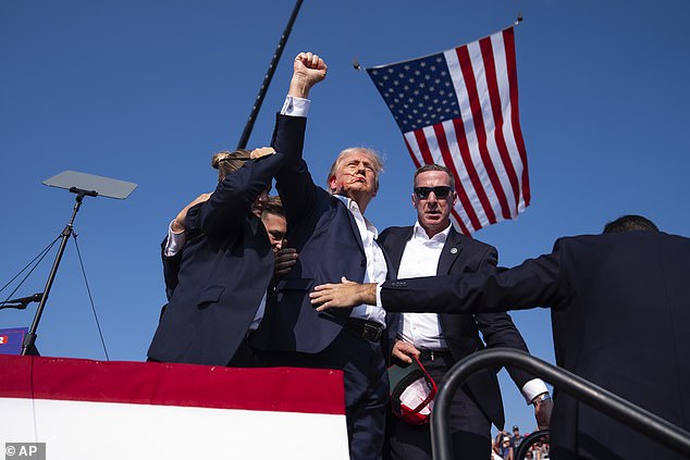 Republican presidential candidate, former President Donald Trump, is surrounded by United States Secret Service agents during a campaign rally, Saturday, July 13, 2024, in Butler, Pennsylvania