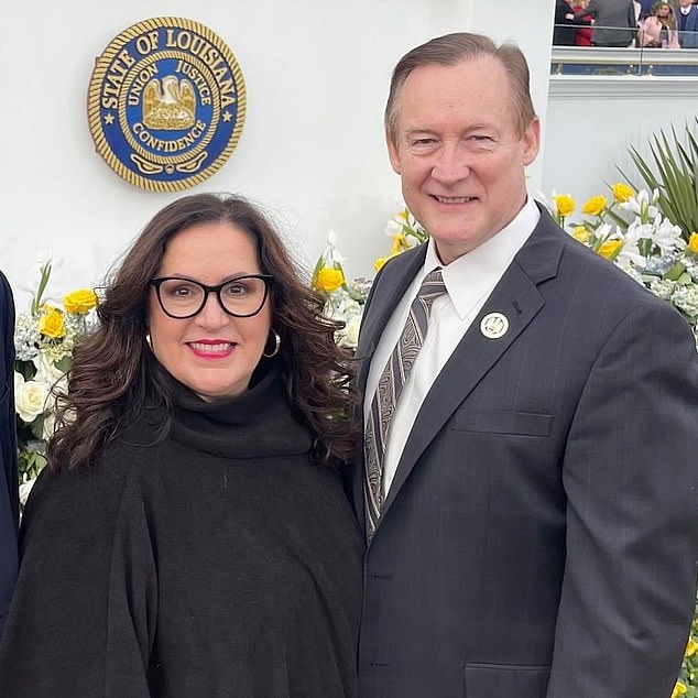 John Raymond and his wife Elizabeth pose in front of the seal of Louisiana