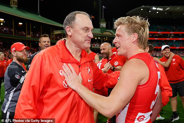 Other AFL supporters believe veteran Sydney Swans coach John Longmire, pictured with star player Isaac Heeney, could put his career on hold