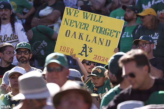 An A's fans hold up a sign after the Oakland Athletics defeated the Texas Rangers