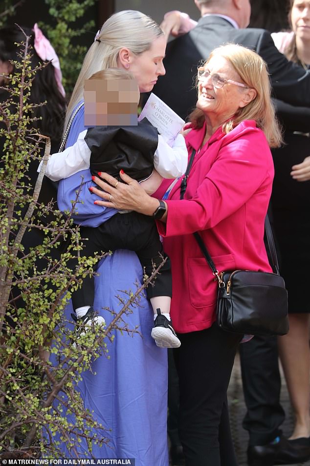 Charlotte's mother, Kelly, was pictured holding her youngest child in her arms at the funeral on Friday