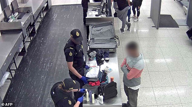 According to the Australian Border Force, it is illegal to purchase pirated and counterfeit goods as they are subject to copyright and trademark laws. (Stock image of a man having his luggage inspected at the airport upon arrival in Australia)