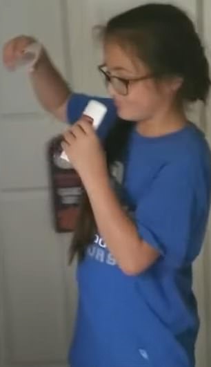 Above is a young girl sniffing a roll-on deodorant while trying to chrome