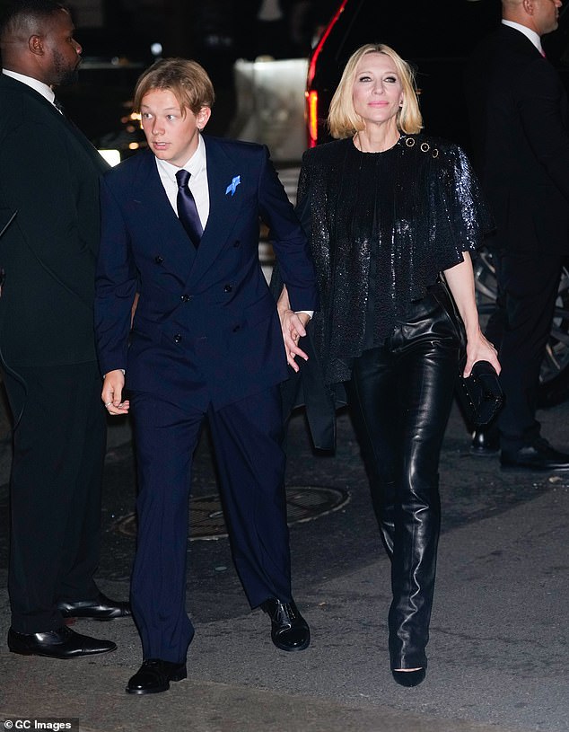 She completed her look with a pair of tiny black heels and a small clutch bag and added a touch of light pink lipstick as she beamed next to her son.