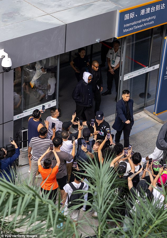 Kanye completed the look with black sunglasses and was surrounded by his entourage as he left the airport after the flight to Haikou.