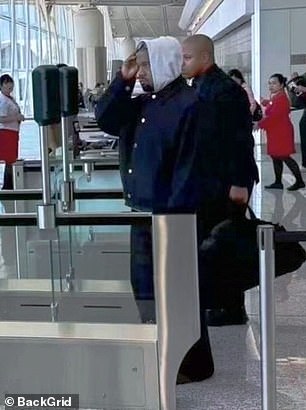 Kanye briefly took off his sunglasses as he walked through the airport