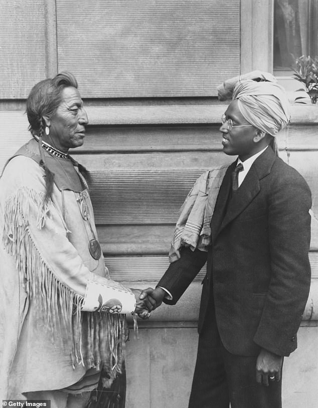 Native America Blackfeet Chief John Two Guns White Calf (1872-1934) shook hands with A Aaron of Madras, India, as they met in the Twin Cities for the Rotary Convention, circa 1925