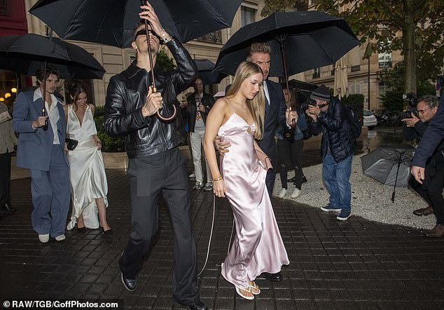 The Beckham family turned heads as they braved the rain on their way to the fashion show