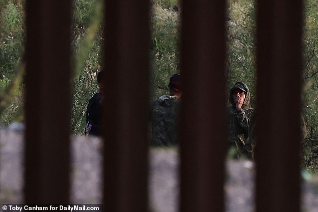 Cartel smugglers in camouflage wait for the perfect moment to sneak their human cargo across the US-Mexico border in Arizona last month