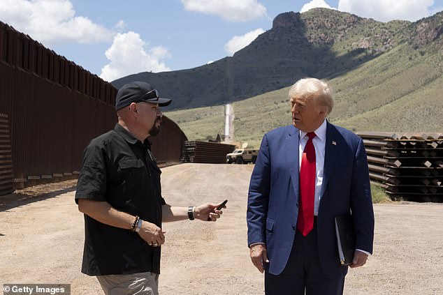 National Border Patrol Council board member Art Del Cueto walks with U.S. Republican presidential candidate and former President Donald Trump along the U.S.-Mexico border south of Sierra Vista, Arizona, on August 22, 2024. Del Cueto told DailyMail.com that Harris had caused the trouble at the Arizona border