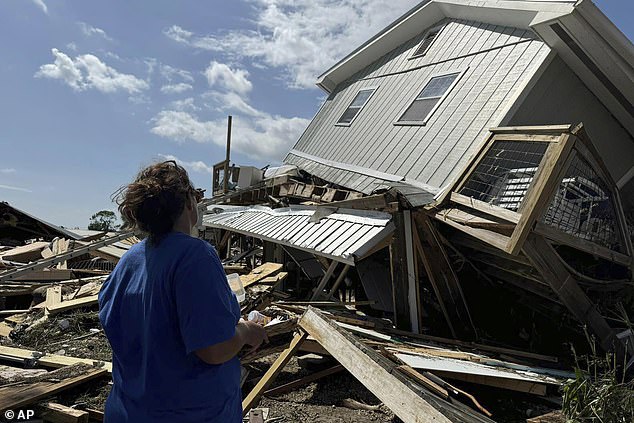 Laurie Lilliott examines what's left of her home after Hurricane Helene passed through the area near Dekle Beach, Florida