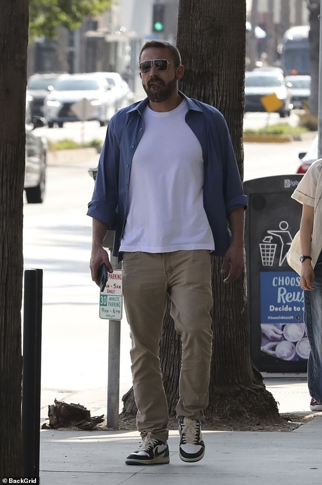 The father of three enjoyed time with his child and kept it low key in a white T-shirt and blue button-up paired with khaki pants