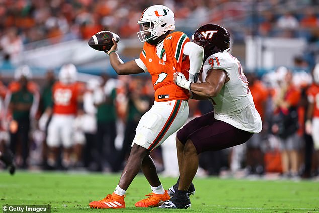 Wilfried Pene of the Virginia Tech Hokies tries to tackle Cam Ward but fails