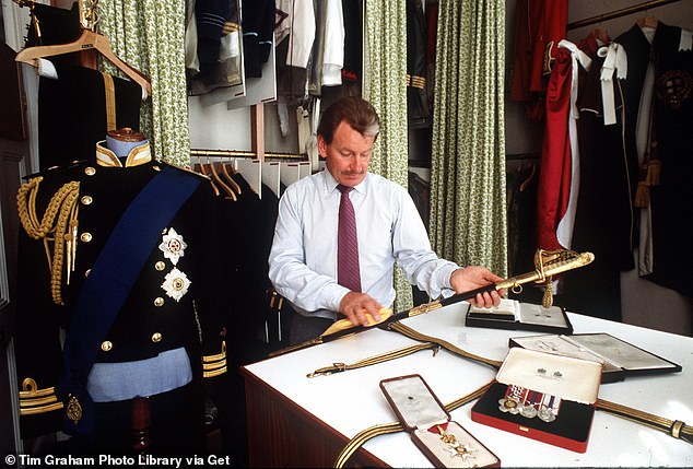 Valet Ken Stronach in the uniform room of Kensington Palace cleaning a ceremonial sword, 1986