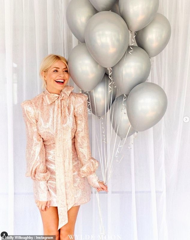 She looked stunning in a light pink leggy dress with cute bow details on it as she posed with some silver balloons