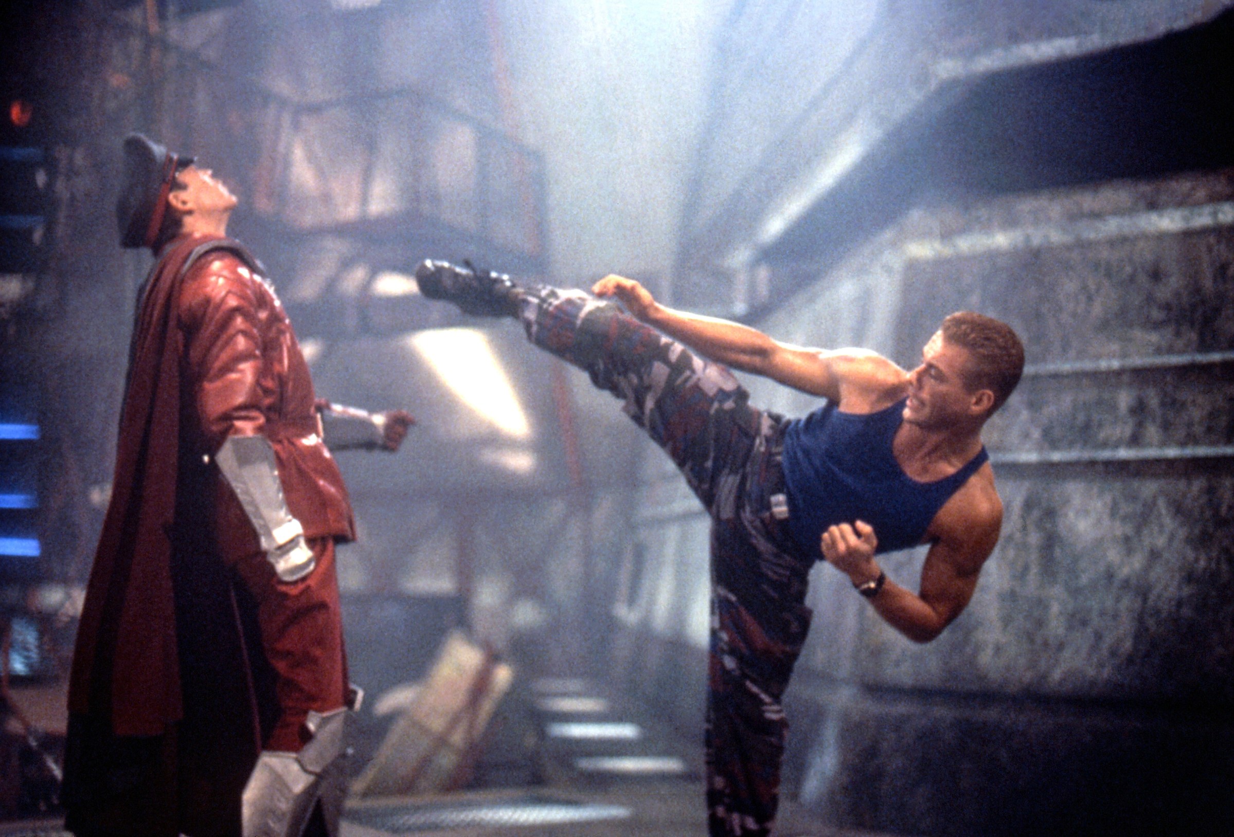 Jean-Claude Van Damme as Colonel Guile delivers a high kick to the face of Raul Julia's M. Bison in the film Street Fighter.