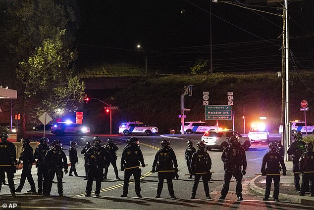 Portland would later repay the police department after a 2020 attempt to divert funds from the department led to unwanted results. Above, officers confront protesters at an ICE facility in Portland in May