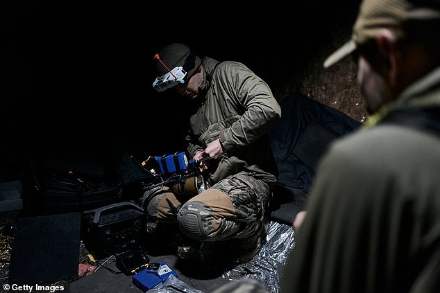 A Ukrainian military pilot of an FPV drone while attaching an explosive to an FPV drone on the front line near Bakhmut on October 24, 2023 in Bakhmut, Ukraine