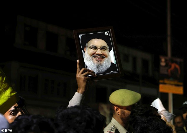 A Shia Muslim from Kashmir holds a photo of deceased Hezbollah leader Hassan Nasrallah