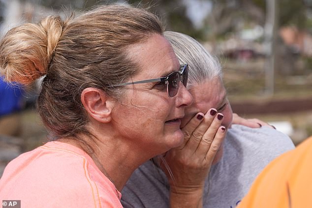 Survivors Tammy Bryan, left, hugs fellow resident Jennifer Lange amid the devastation in the aftermath of Hurricane Helene in Horseshoe Beach on Saturday, September 28