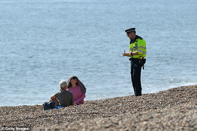 A police officer asks the public to leave Brighton beach in April 2020 as strict rules were in place