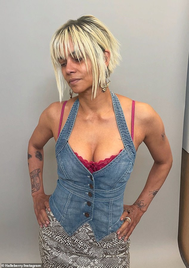 She put on a busty show in a low-cut denim halter top over a magenta bra