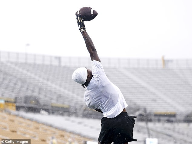 Hunter extends a pass from Shedeur Sanders during Saturday's warm-up in Orlando