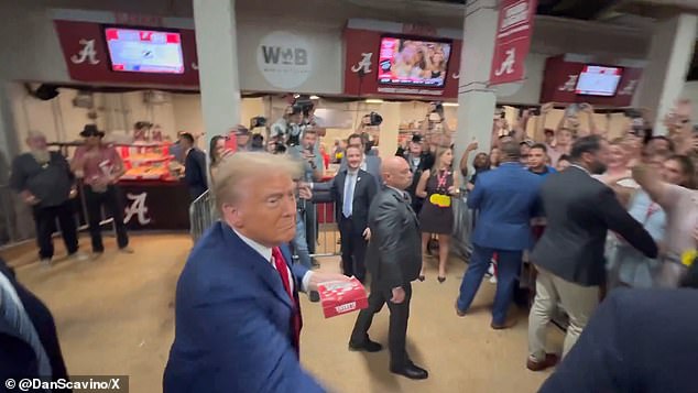 Former President Donald Trump throws food to fans behind barricades in the stadium