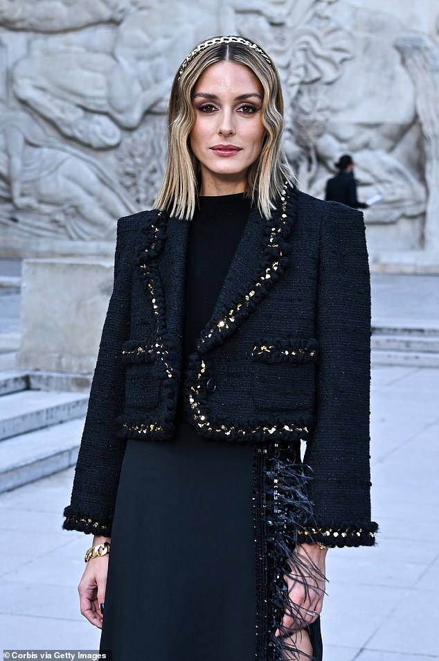 She modeled a beautiful black woven blazer with gold trim and a long skirt with a sexy slit and feathers