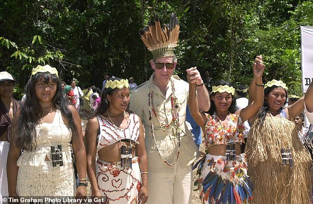 Pictured: Prince Charles in Guyana, South America, wearing garlands and a headdress of feathers and palm leaves