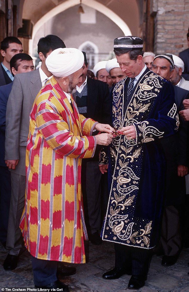 Pictured: Prince Charles is presented with a traditional wedding dress of blue velvet, embroidered with gold, during a trip to Tashkent, the capital of Uzbekistan in 1996