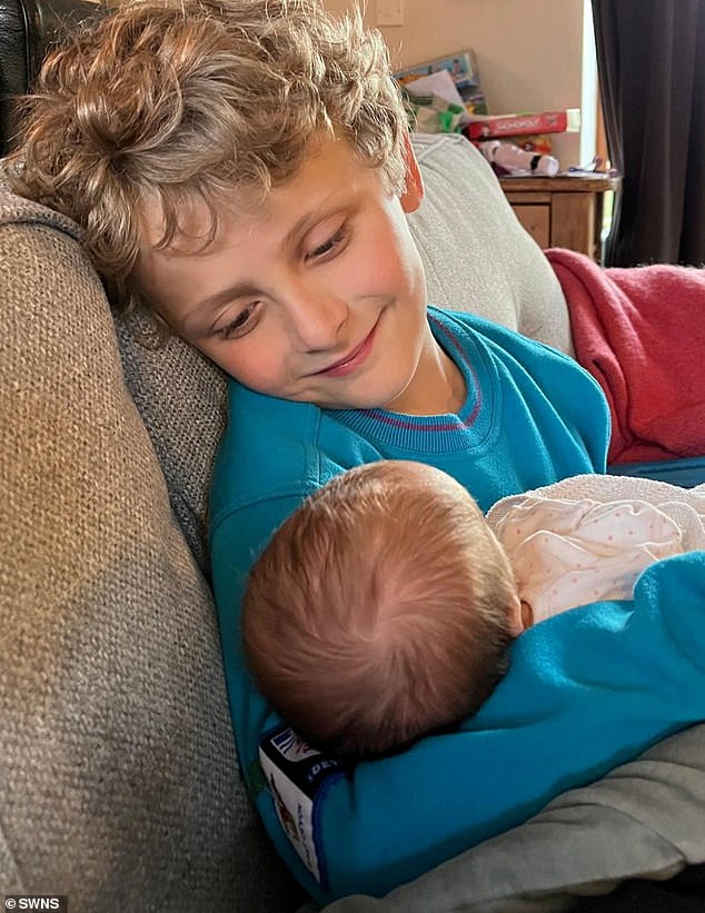 Beth's son Thomas holds his younger sister Grace. The mother recalled her IVF journey: 'You run, fall and pick yourself up - three months after holding a funeral for our stillborn baby and having a miscarriage, I discovered I was pregnant with Tom'