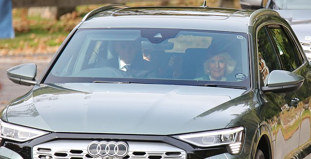 Sitting in the front passenger seat, with a beaming smile, the Queen put on a stylish display in a green coat and red beret with feathers