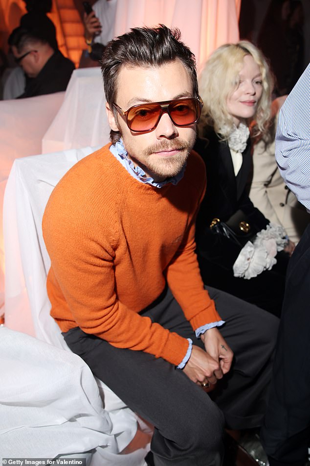 He looked dapper in a bright orange sweater and blue ruffled shirt as he made a rare public appearance to enjoy the show