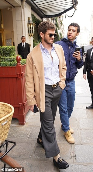 Actor Andrew Garfield leaves his hotel with a beaming smile