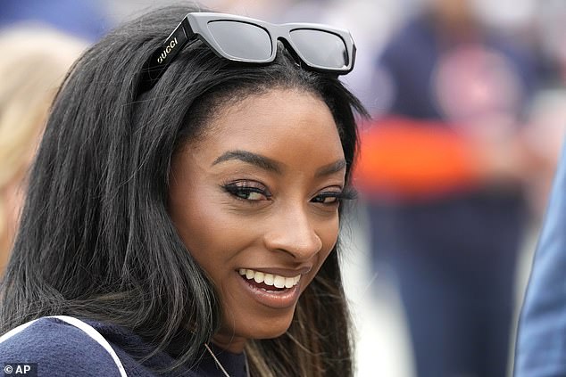 Biles, who wore Gucci sunglasses, smiles at the camera before the Bears game