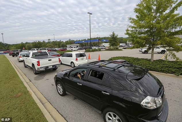 Residents wait in line for gas at Sam's Club in the aftermath of Hurricane Helene Sunday