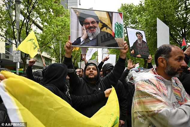 Some protesters held framed photos of Hezbollah's leader Hassan Nasrallah, who was killed by an Israeli airstrike in Beirut on Friday (photo: a protester in Melbourne)